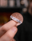 Hand holding a coin with tinfoil wrapped around it against a blurred background